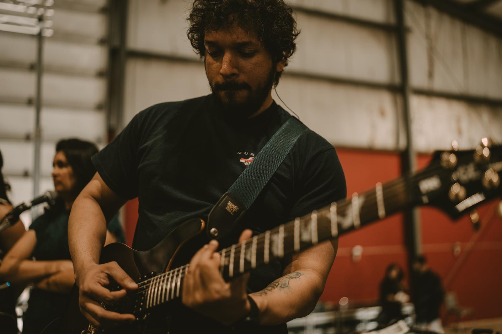 Glen Fernandez playing guitar on stage