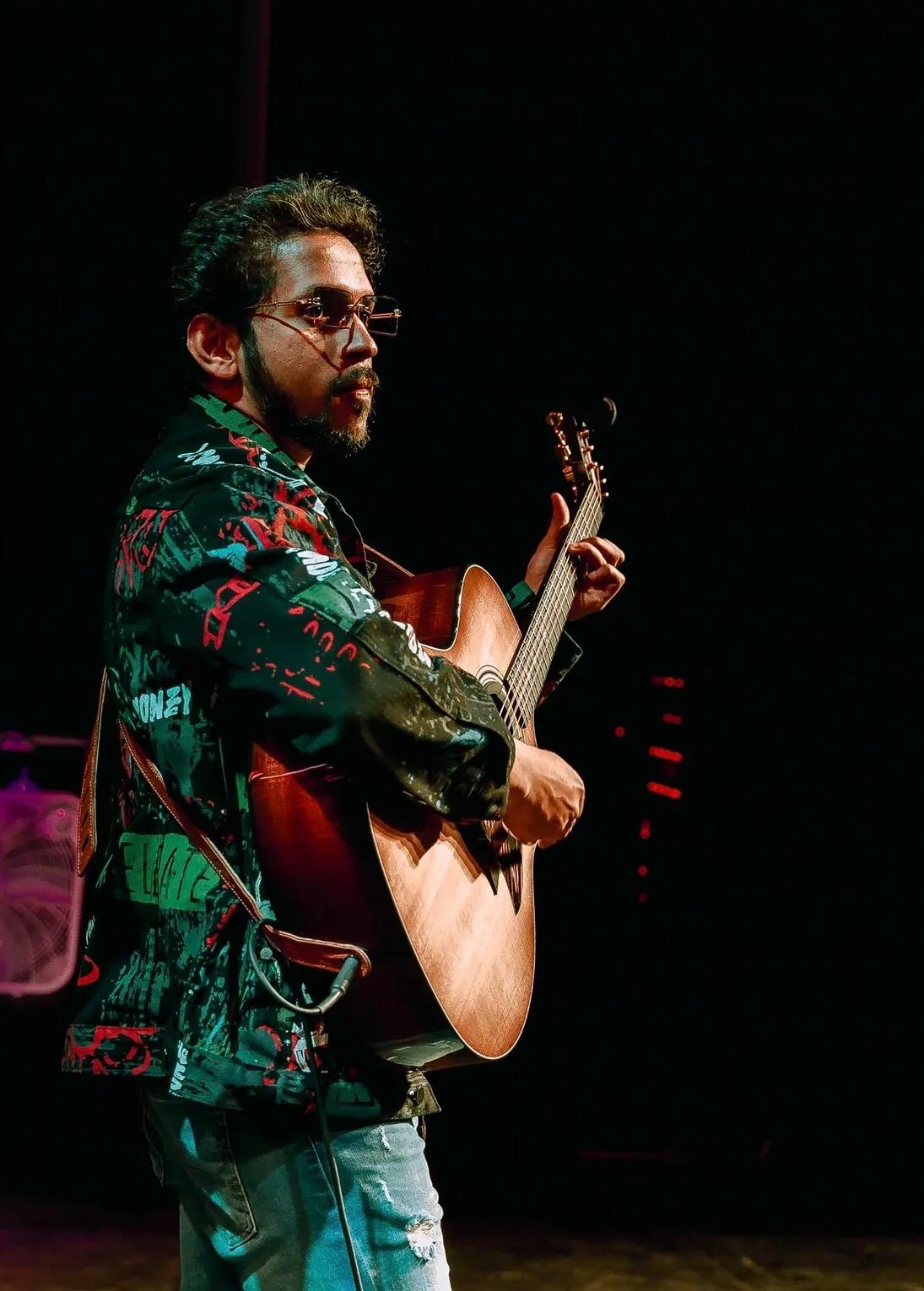 Glen Fernandez performing acoustic guitar