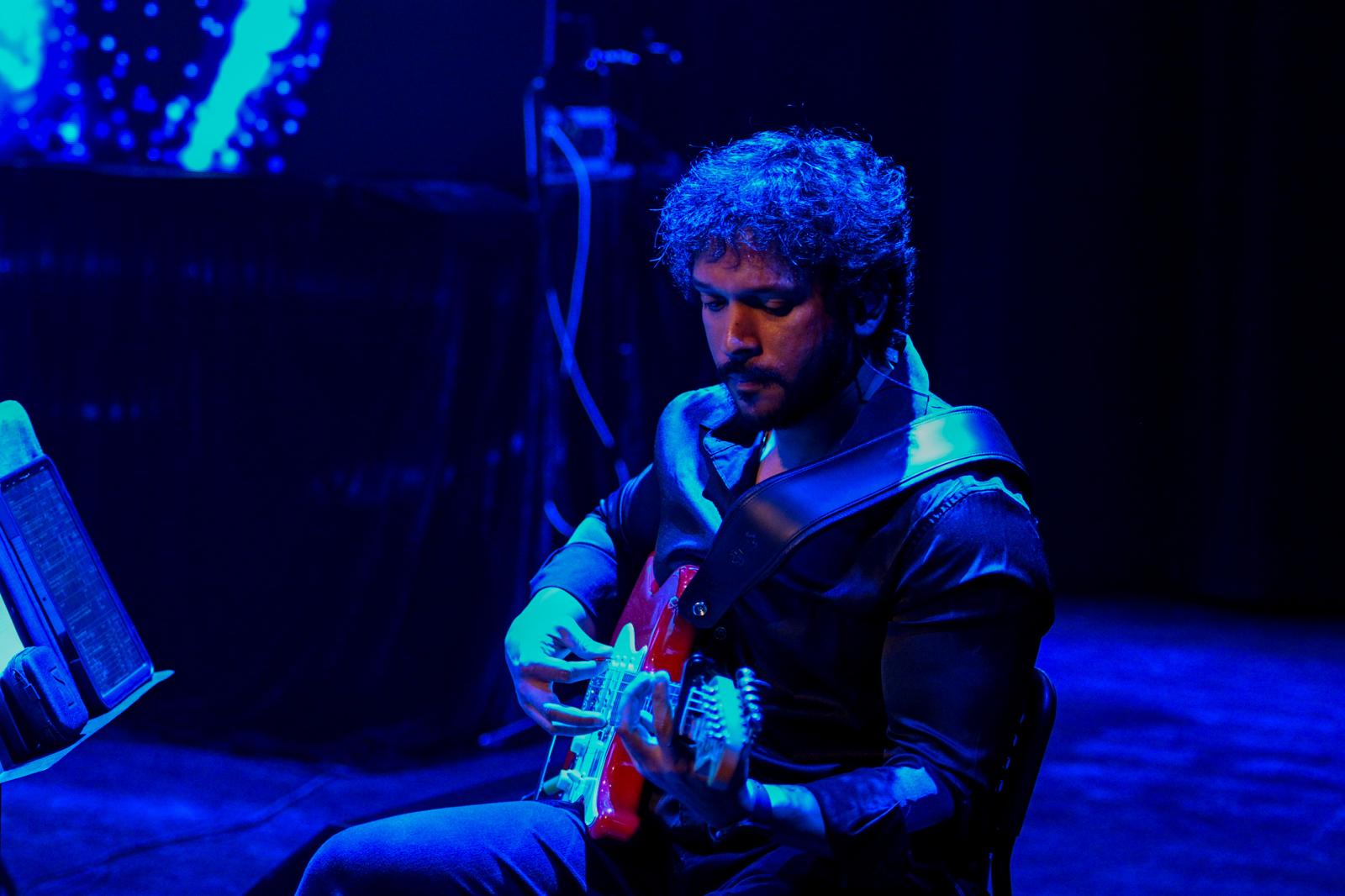Glen Fernandez performing with guitar